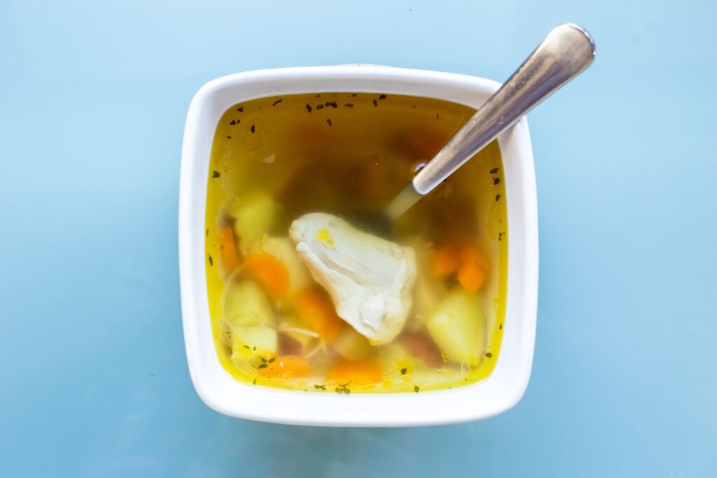 soup with sliced lemon in white ceramic bowl